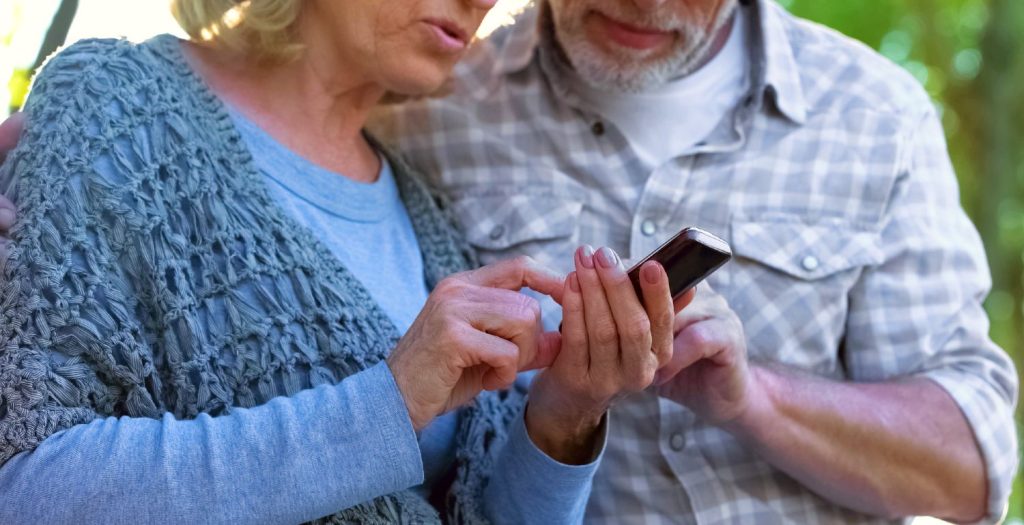 Ældre ægtepar anvender mobiltelefon