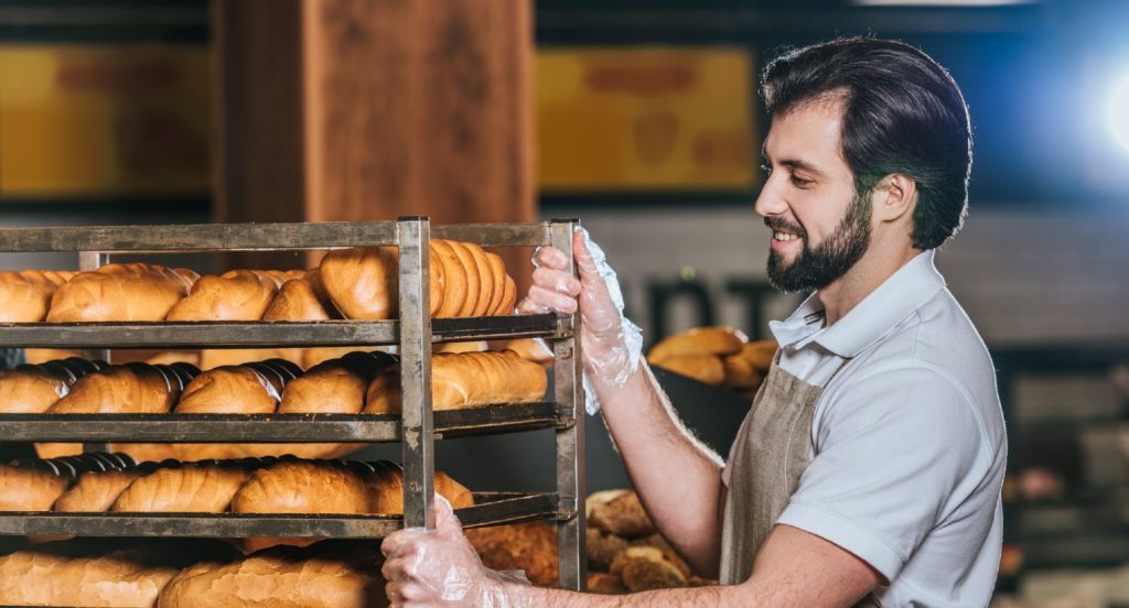 Medarbejder flytter et fyldt stik i en bagerbutik