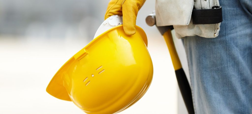 Bygningsarbejder holder gul hat i hånden